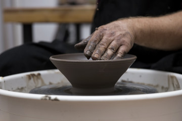 Artist makes clay pottery on a spin wheel