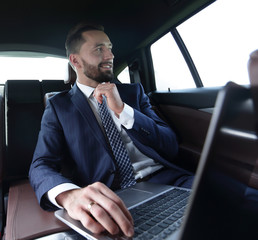 Confident businessman sitting in car