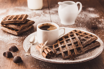 Viennese Belgian chocolate waffles on a plate sprinkled with powdered sugar Cup of aromatic coffee...
