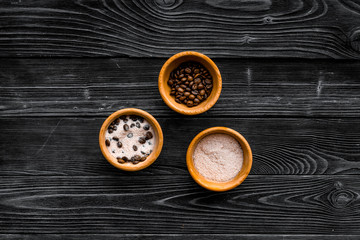 Cosmetics for skin care and relaxation. Chocolate brown spa salt on dark wooden background top view copy space