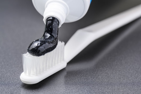 Black Charcoal Whitening Toothpaste On White Toothbrush