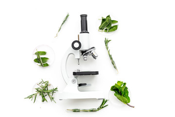 Food analysis. Pesticides free vegetables. Herbs rosemary, mint near microscope on white background top view copy space