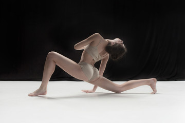 Young teen dancer on white floor background.