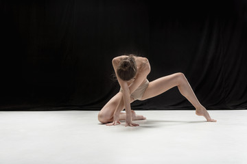 Young teen dancer on white floor background.