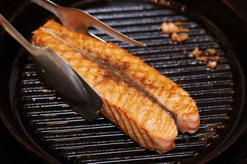 Cooking salmon steak fish on the grill pan