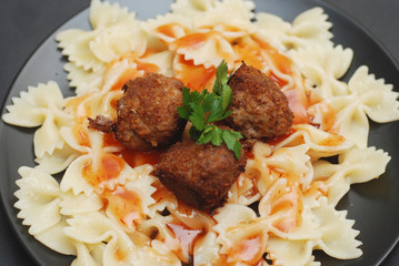Farfalle Pasta with Meatballs and Sauce. Close Up Pasta in Black Plate. homemade Food.