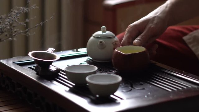Hand Holding Green Tea in Traditional Chinese Tea Ceremony. Set of Equipment for Drinking Tea