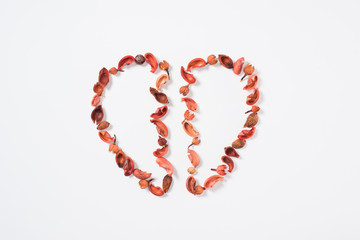 top view of two halves of heart from dried fruits isolated on white, valentines day concept