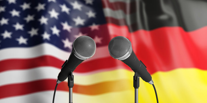 USA and Germany relations. Two cable microphones in front. Flags for background. 3d illustration