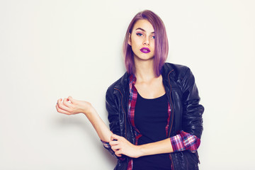 Modern young woman with purple hair and lipstick posing