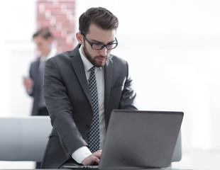 Portrait of businessman in front of laptop computer