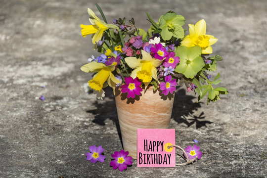bouquet of spring flowers and narcissus   with happy birthday card