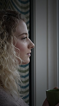 Depressed Woman gazes out the window 