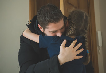 Father hugging her daughter after long trip.