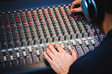 male sound engineer hands working on audio mixing console. music background