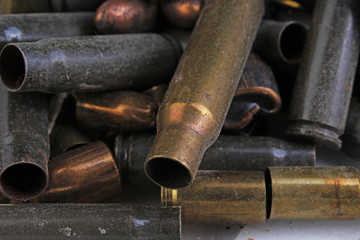 Heap of gun bullets. Weapon Cartridge case sleeve background texture, 7.65, and 9mm. Weapon cartridge sleeves.Gun bullet pattern close up.