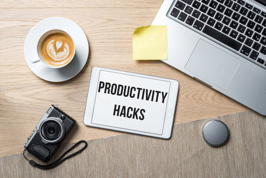 Productivity hack written on tablet in office as flatlay