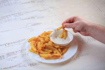 French fries on a table on a light table with sauce.