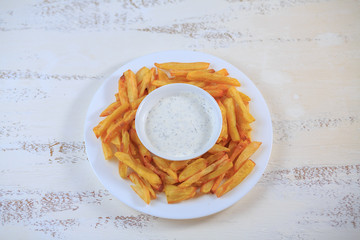 French fries on a table on a light table with sauce.