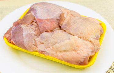 Raw chicken thighs in the tray.