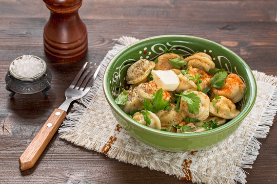 Meat dumplings with pepper and butter on table. Pelmeni russian national dish