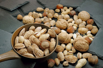 Rożne rodzaje orzechów na czarnym kamieniu łupkowym