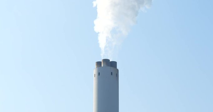 Smoke stack emit smoke over blue sky