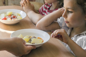 grand daughters have dinner with their grandmother