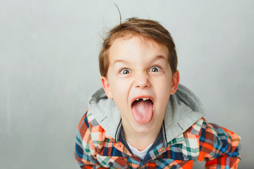 prank a boy in a plaid shirt shows tongue