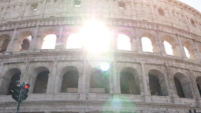 Young hipster man riding bike walking at colosseum in Rome city centre on sunny day slow motion steadycam