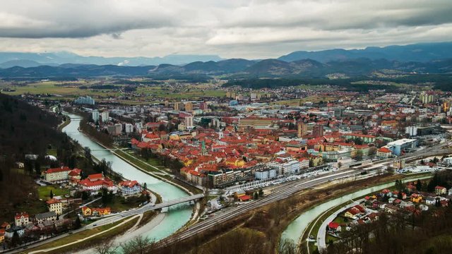 Celje, Slovenia. Car traffic in Celje, Slovenia. Bridge over the Savinja river. Aerial view of city historical center from the castle. Time-lapse during the cloudy day with mountains