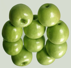 Fresh ripe green apples with green leaves as background