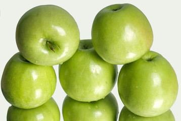 Fresh ripe green apples with green leaves as background