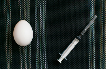 The concept of unnatural, chemical food. GMO. Chicken eggs and syringe.