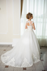 Beautiful bride in wedding dress before wedding ceremony in great hall