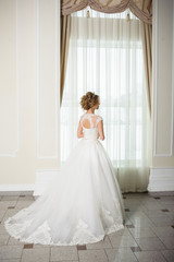 Beautiful bride in wedding dress before wedding ceremony in great hall