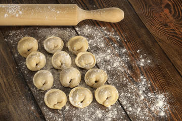 homemade dumplings and rolling pin. wooden table.