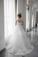 Beautiful bride in wedding dress before wedding ceremony in great hall