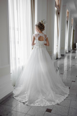 Beautiful bride in wedding dress before wedding ceremony in great hall