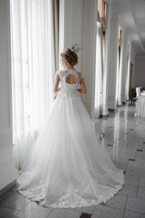 Beautiful bride in wedding dress before wedding ceremony in great hall