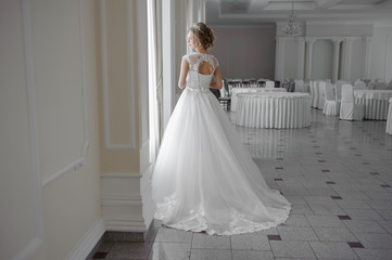 Beautiful bride in wedding dress before wedding ceremony in great hall