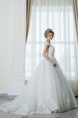 Beautiful bride in wedding dress before wedding ceremony in great hall