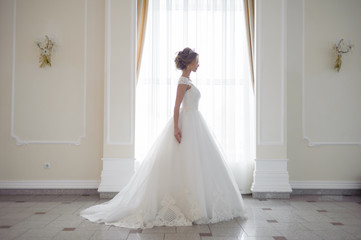 Beautiful bride in wedding dress before wedding ceremony in great hall
