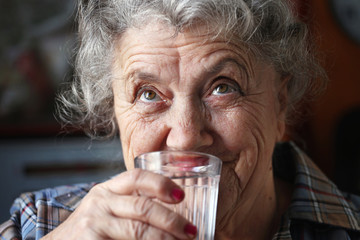 Elderly woman drinks water
