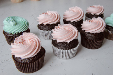 Tasty cupcakes on background table. Homemade chocolate muffin cupcake with cream buttercream icing. Birthday cupcake. Valentine cupcake sweets. Close up view delicious sweet dessert