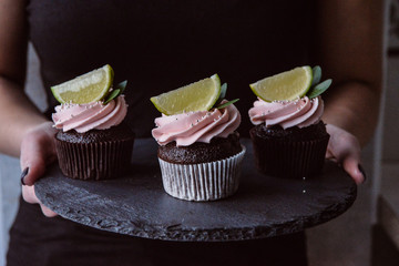 Tasty cupcakes on background table. Homemade chocolate muffin cupcake with cream buttercream icing. Birthday cupcake. Valentine cupcake sweets. Close up view delicious sweet dessert