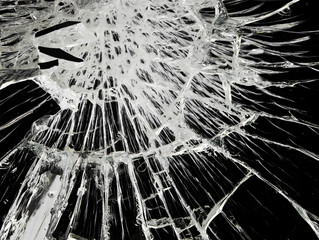 textured surface of a dark mirror coated with fine and large white cracks and splinters