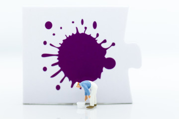 Miniature people: Workers are painting color on the puzzle. Image use for business concept.