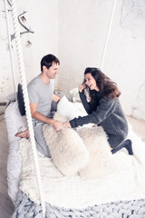 Happy Smiling Couple in love. Valentine's day. Winter portrait. Handsome young man and beautiful woman on a date spending time together at home scandinavian style.  Romance, family and love concept. 