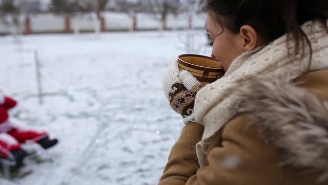 Girl drinks tea in winter in the fresh air